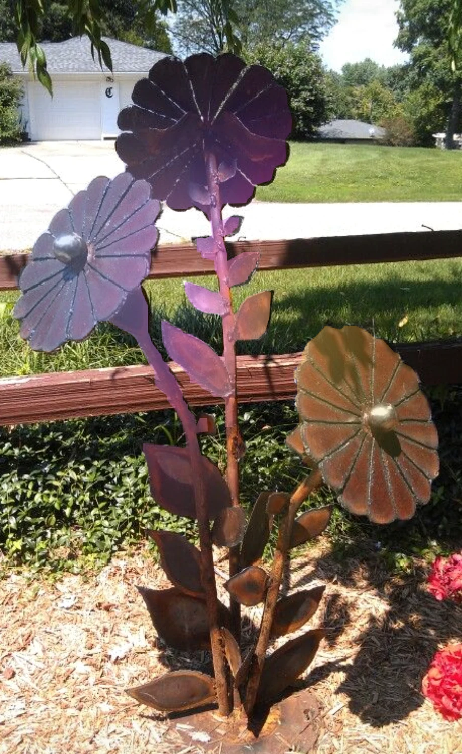 Tall metal flowers in a landscaped garden